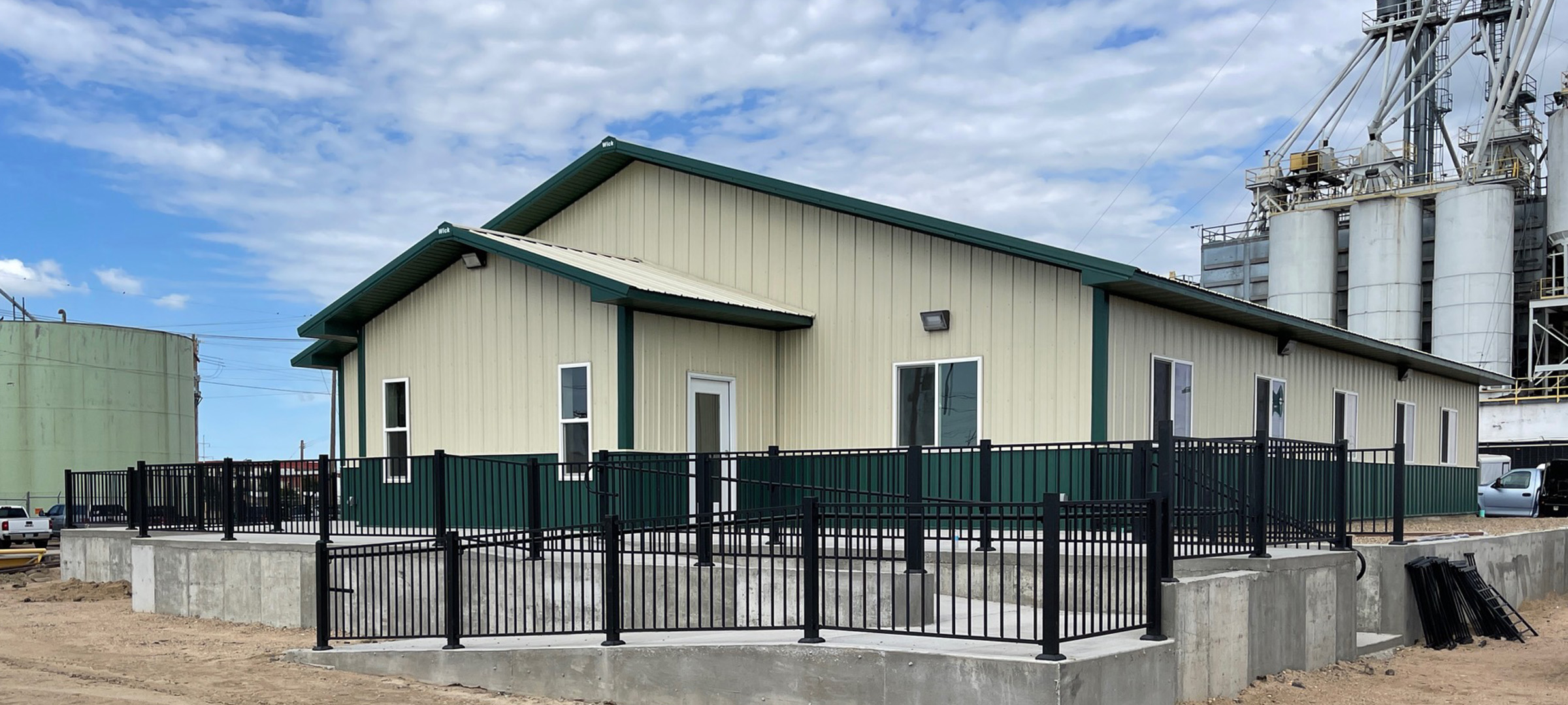 yellow and green post frame commerical building located in an industrial park