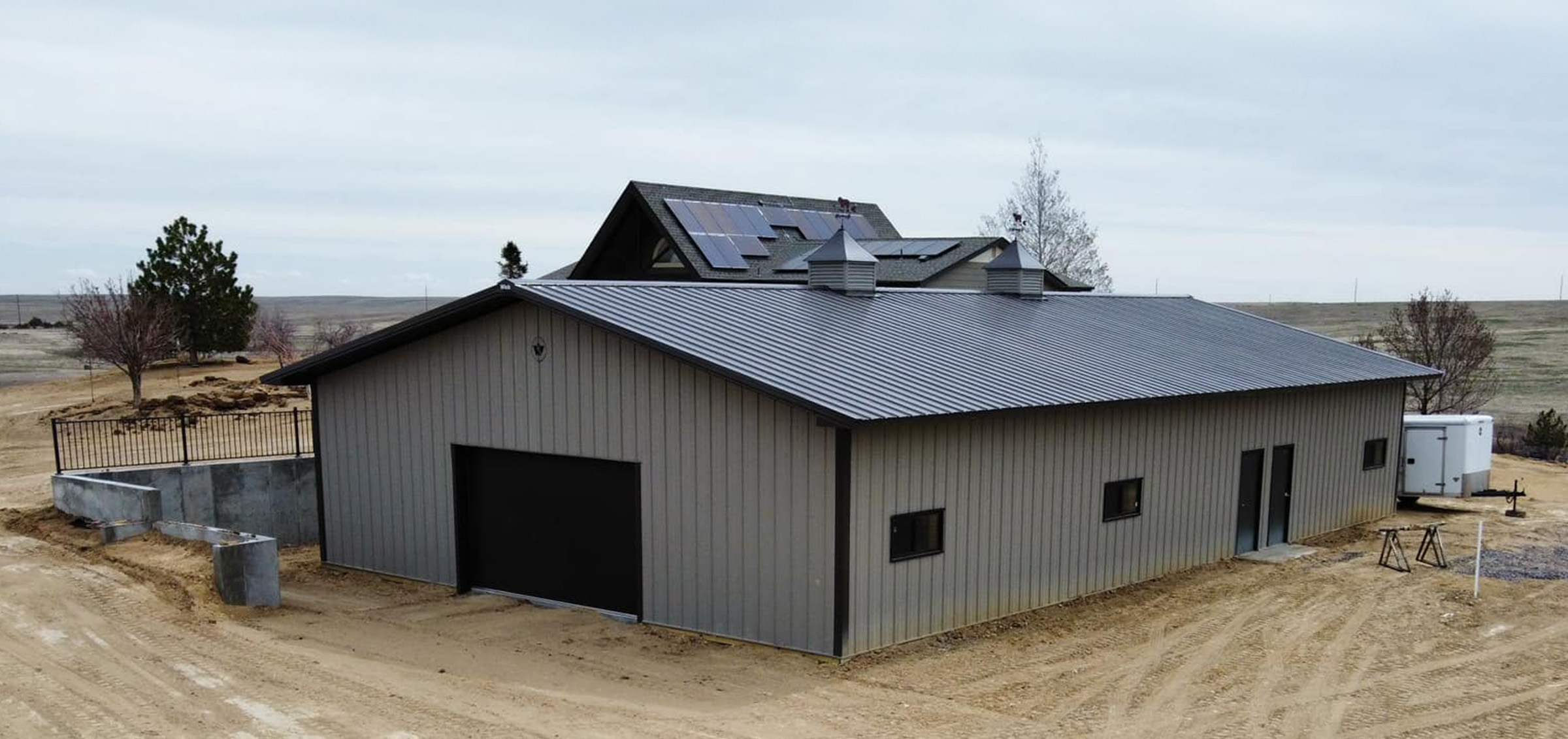 Gray and black suburban post frame building